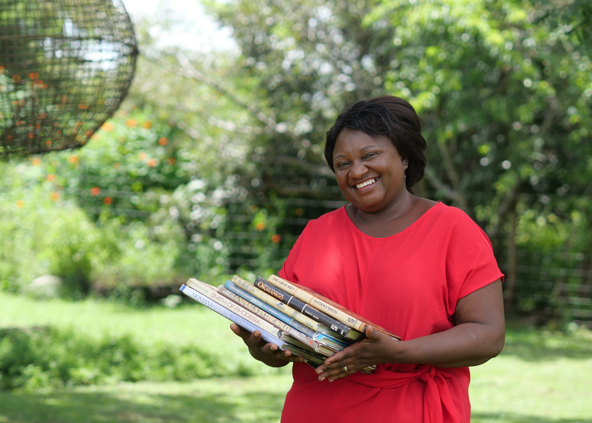 A woman smiling holding books